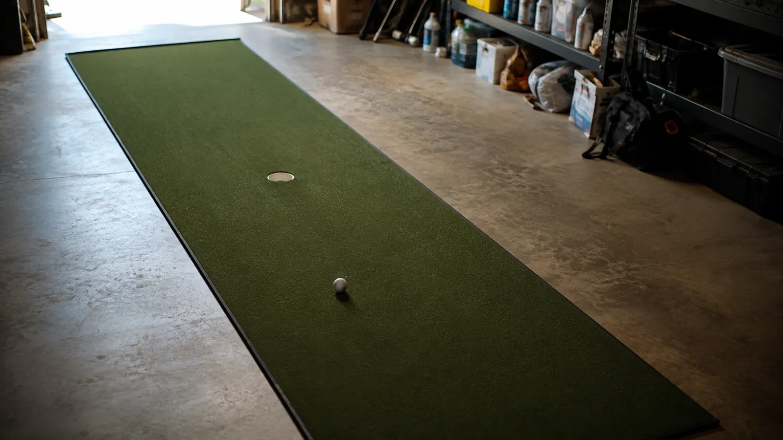 A golf ball sitting a few feet from the middle cup on an indoor putting green